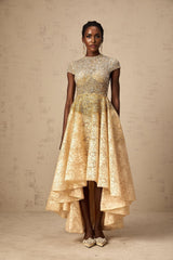 Woman wearing a neutral colored sequined dress with high low hemline
