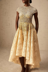 Woman wearing a neutral colored sequined dress with high low hemline