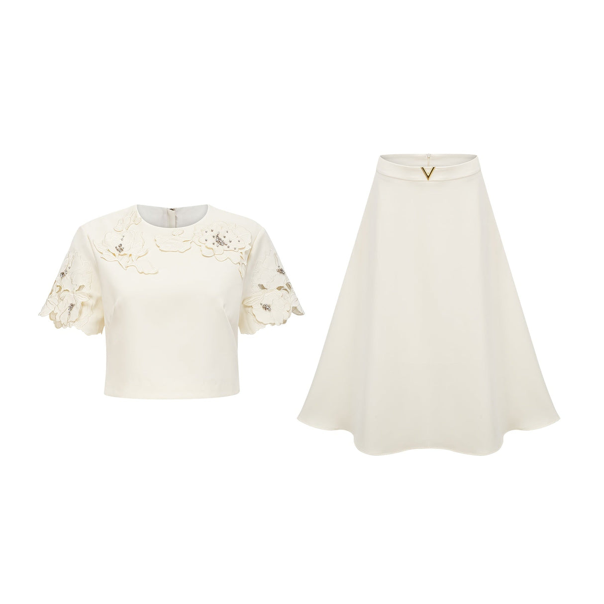 Woman wearing a neutral colored twopiece outfit with a sleeveless top and skirt featuring threedimensional petal details