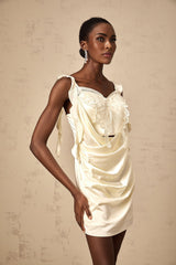 Woman wearing a neutralcolored mini dress with butterfly print and draped design