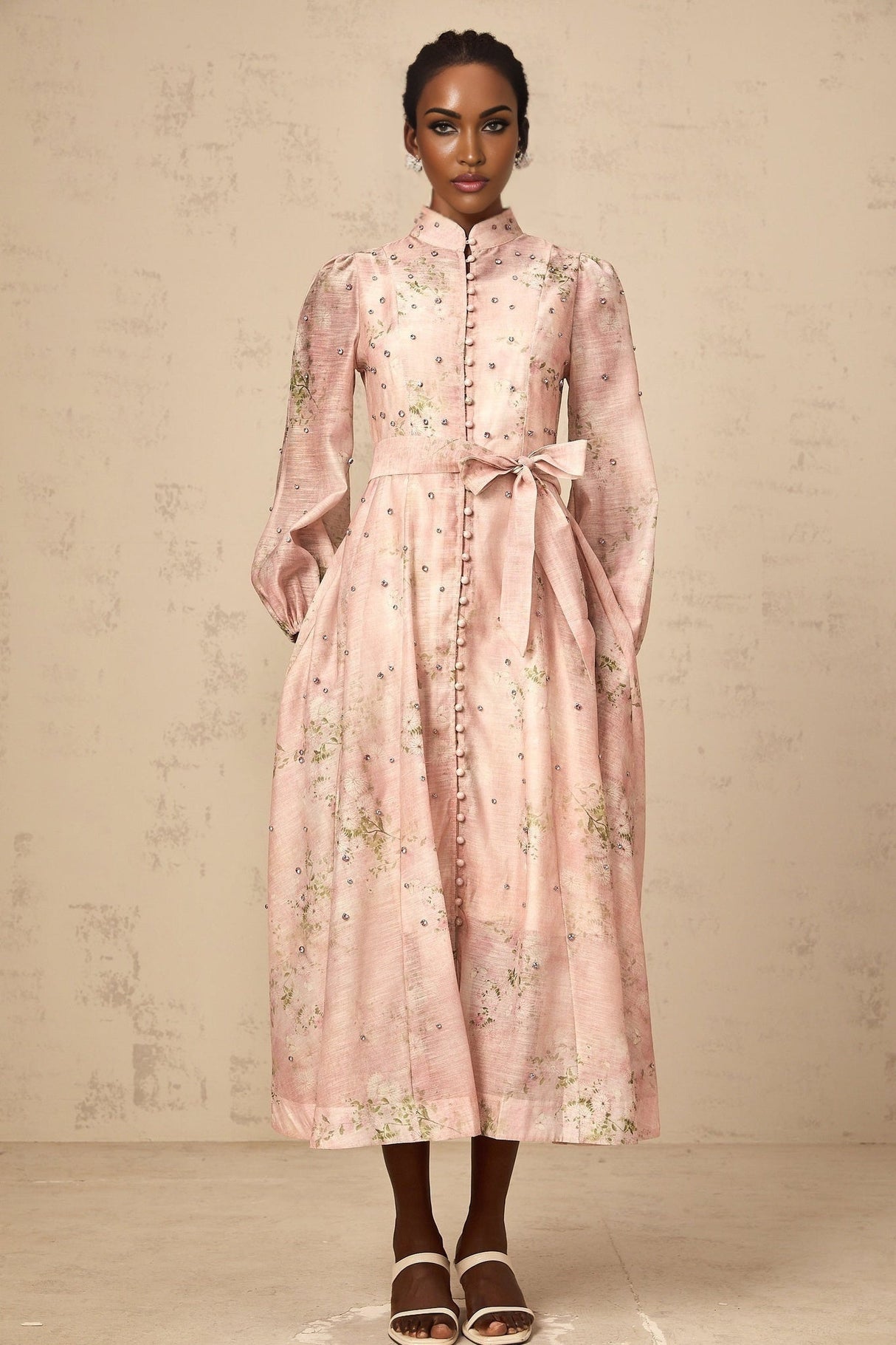 Woman wearing a pink midi dress with floral print and embellishments