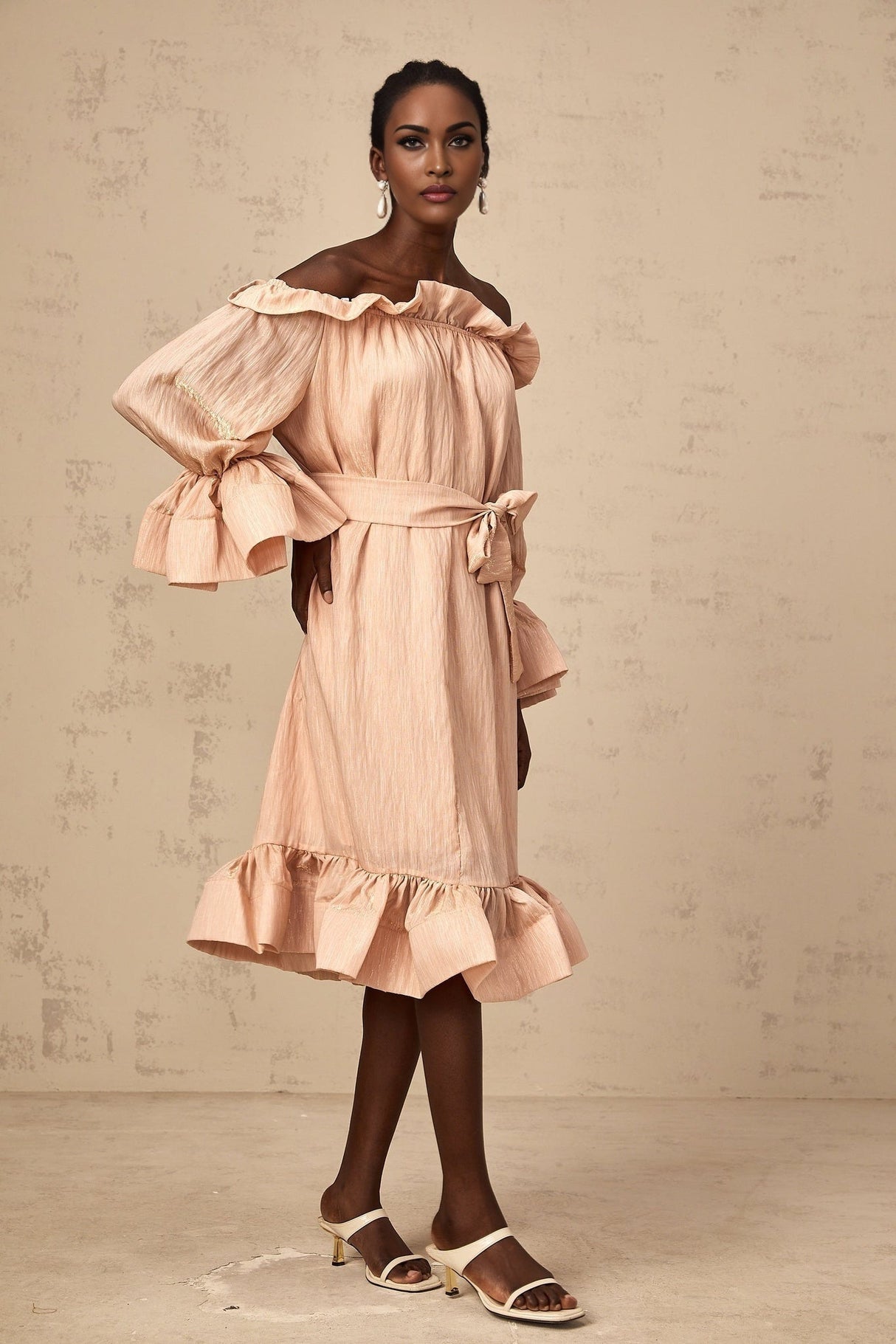 Woman wearing a pink midi dress with tied waist and ruffled details