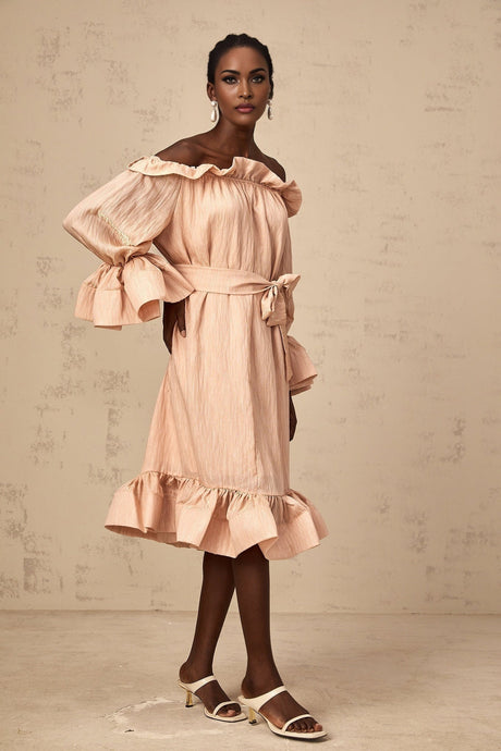 Woman wearing a pink midi dress with tied waist and ruffled details