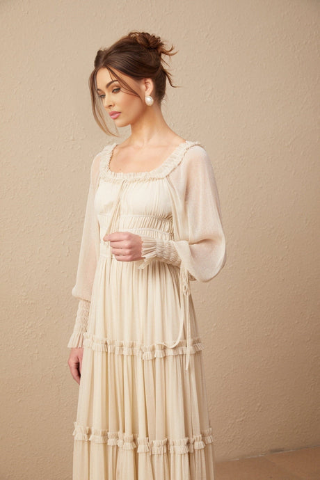 Woman wearing a pleated metallic midi dress with shirred detailing and a flowy silhouette named Camille