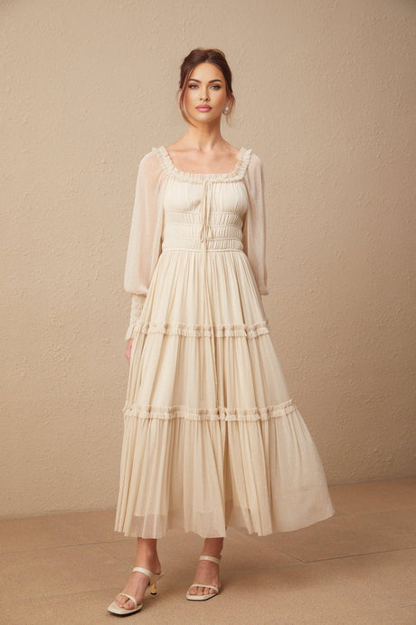 Woman wearing a pleated metallic midi dress with shirred details and a flowing skirt
