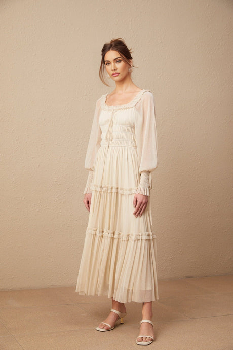 Woman wearing a pleated metallic midi dress with shirred details and a flowy silhouette in a shimmering fabric