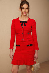 Woman wearing a red braided waffle knit jacket with matching skirt Cynthia set