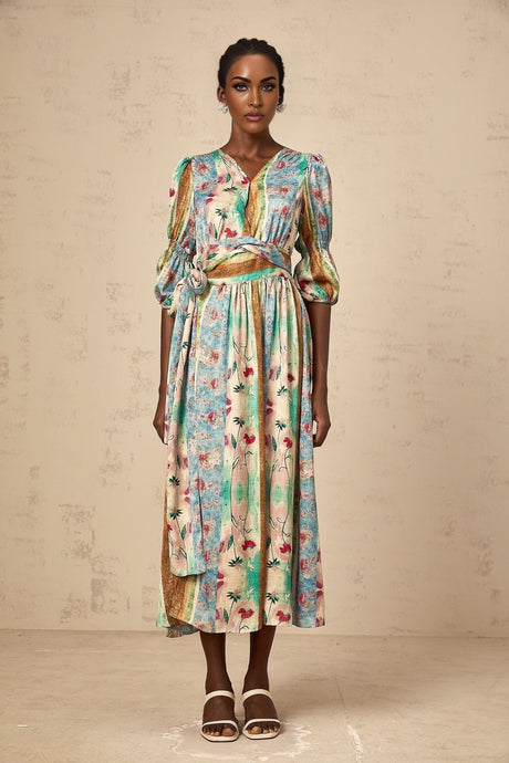 Woman wearing a red floral print wrap dress with midi length sleeves and flowing skirt