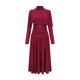 Woman wearing a red midi dress with ruched details and a flap design on the bodice