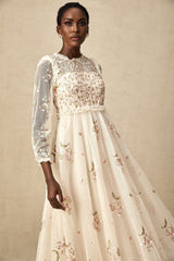 Woman wearing a sheer tulle midi dress with delicate floral embroidery in Celine style