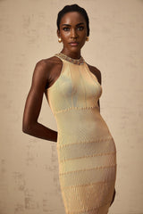 Woman wearing a shimmering gold sequined midi dress with ribbed knit texture and fitted silhouette