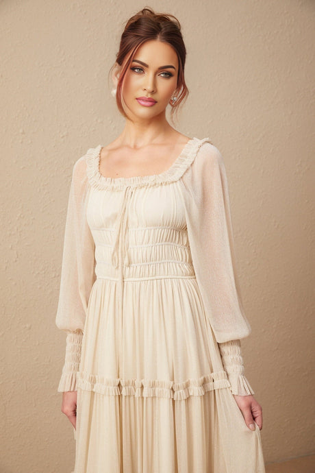 Woman wearing a shimmering metallic pleated midi dress with shirred detailing and a flowy silhouette