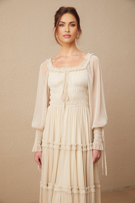 Woman wearing a shimmering metallic pleated midi dress with shirred detailing and a flowy silhouette