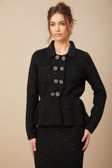 Woman wearing a shimmering waffle knit jacket and matching skirt set with sequin embellishments in a soft color