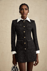 Woman wearing a short black dress with tweed fabric and sequin panels Audrey style mini dress with a mix of textures
