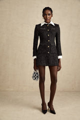 Woman wearing a short black dress with tweed fabric and sequin panels Audrey style mini dress with a mix of textures