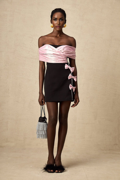 Woman wearing a short colorblocked dress with a bow detail