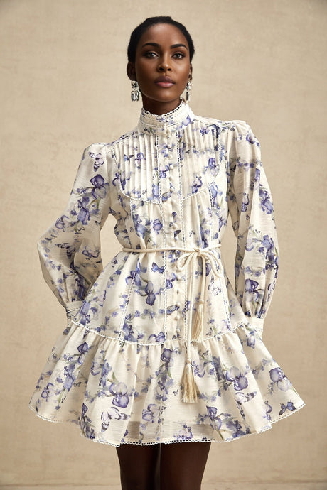 Woman wearing a short flared dress with floral print pattern on light chiffon fabric
