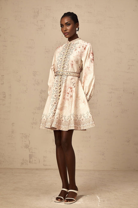 Woman wearing a short floral print dress with a belt cinched at the waist