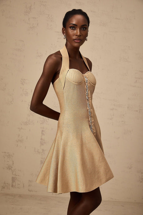 Woman wearing a short khaki knitted dress with embellishments standing in a neutral pose
