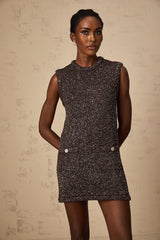 Woman wearing a short knit dress in barley brown color with sequin embellishments