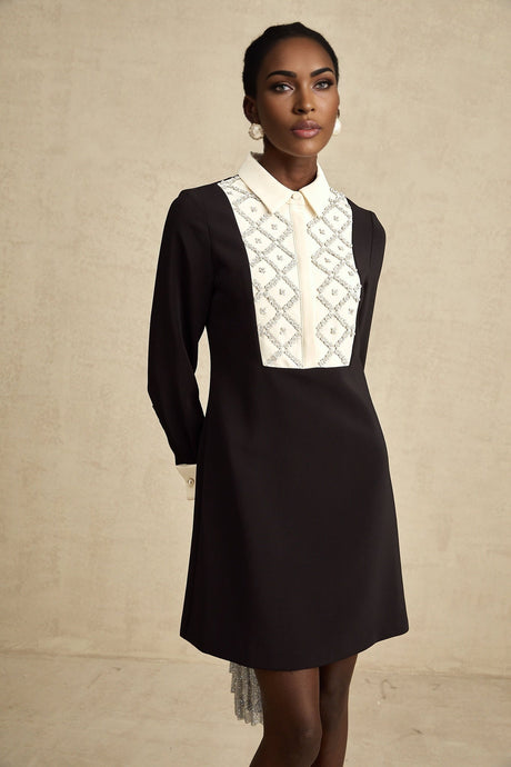 Woman wearing a short mini dress with contrasting colors and embellishments