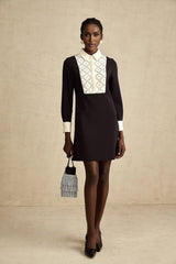 Woman wearing a short mini dress with contrasting colors and embellishments