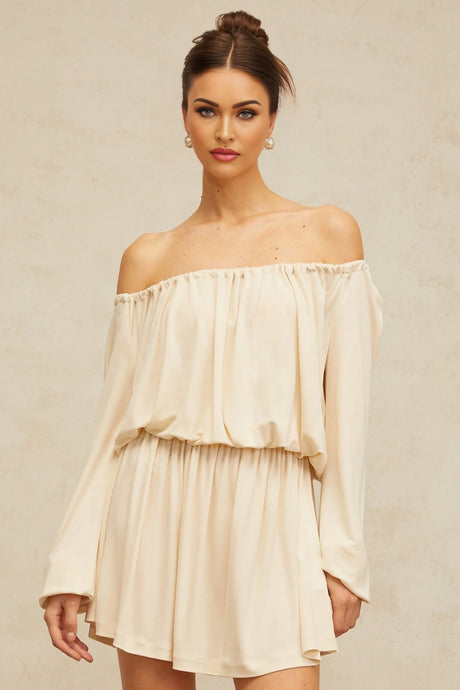 Woman wearing a short neutral colored structured mini dress with a fitted silhouette and clean lines