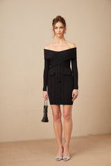 Woman wearing a short offshoulder dress with ribbed texture in light color standing against plain background