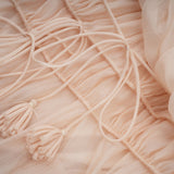 Woman wearing a short offshoulder dress with ruched detailing and layered skirt The dress has selftie straps and a fitted silhouette