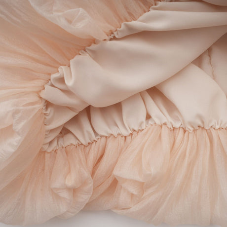 Woman wearing a short offshoulder dress with ruched detailing and selftie straps layered design in pastel color