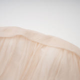 Woman wearing a short offshoulder dress with ruched details and selftie elements The dress has layered fabric and falls above the knee