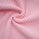 Woman wearing a short pink knit dress with beaded embellishments standing in a neutral setting