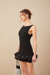 Woman wearing a short ruffled dress with an open back design