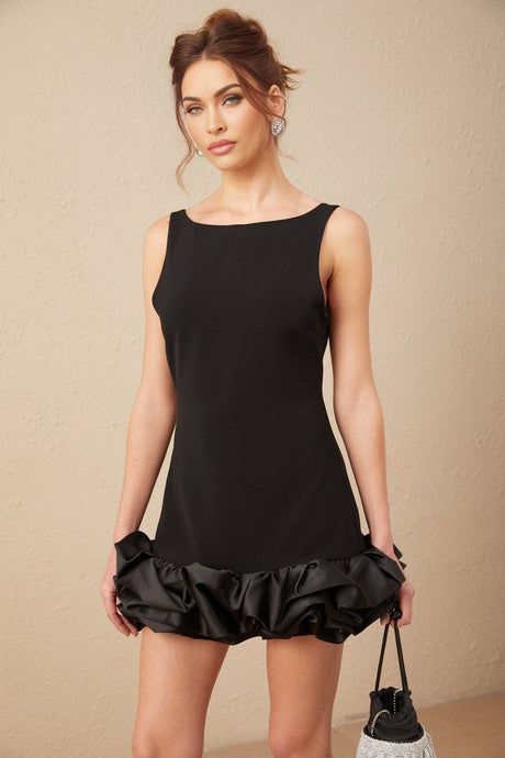 Woman wearing a short ruffled dress with an open back design