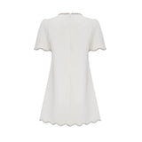 Woman wearing a short white dress with crystal embellishments