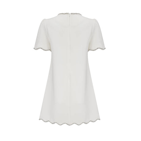 Woman wearing a short white dress with crystal embellishments