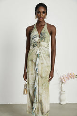Woman wearing a sleeveless midi dress with a neckholder style and ombre print pattern fading from dark to light colors