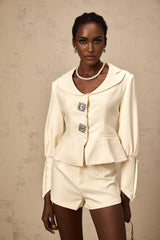 Woman wearing a sparkling crystalembellished jacket and matching shorts set in a glamorous party outfit