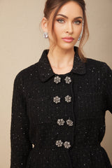 Woman wearing a sparkly sequined waffle knit jacket and matching skirt set in a stylish pose