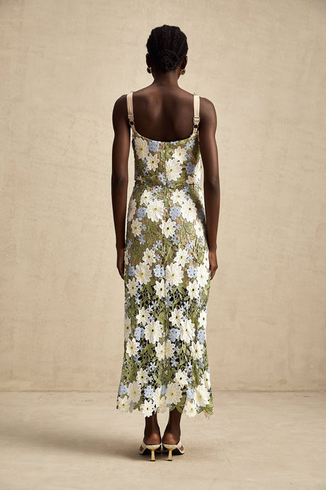 Woman wearing a white midi dress with floral embroidery and cutout details