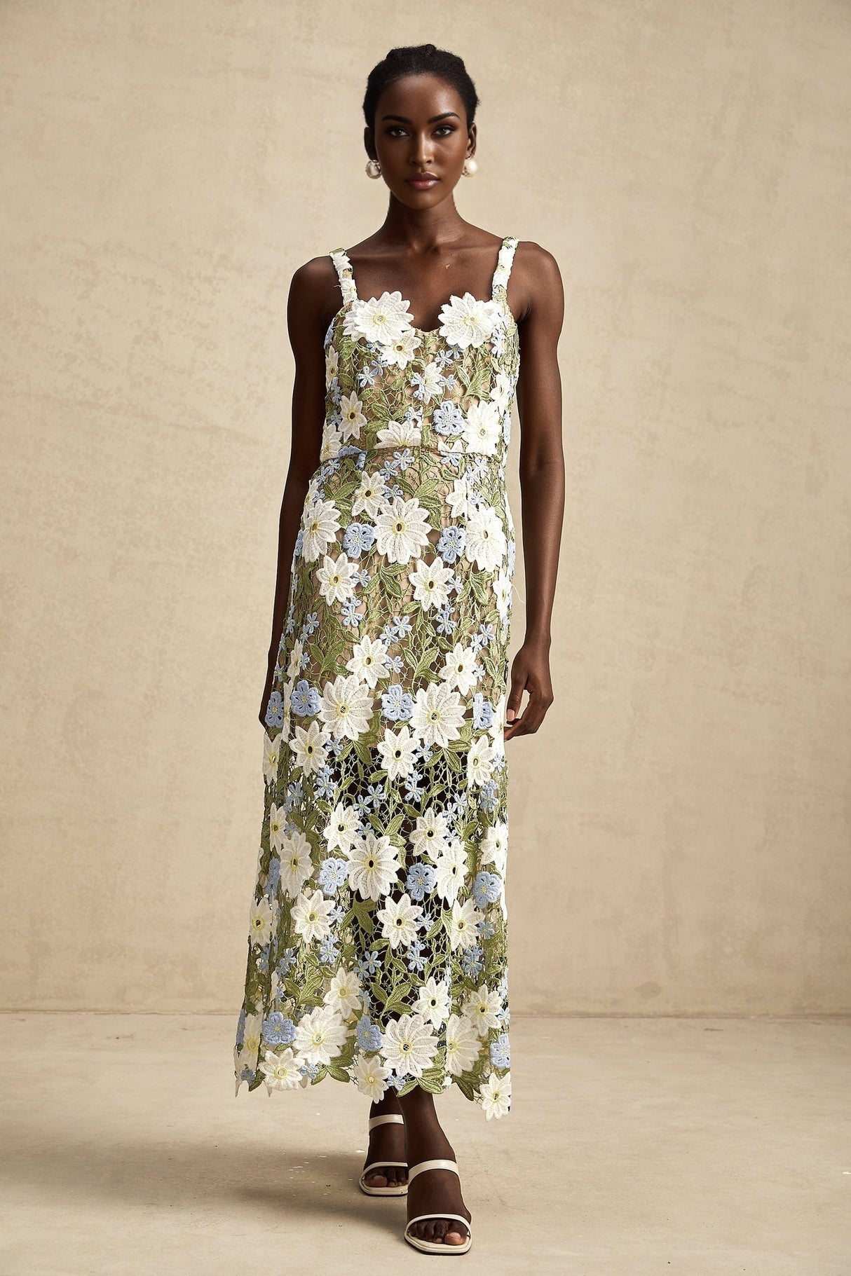 Woman wearing a white midi dress with floral embroidery and hollow cutout details