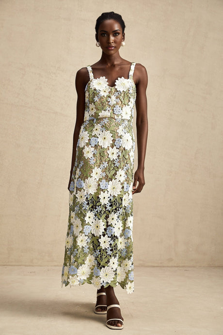 Woman wearing a white midi dress with floral embroidery and hollow cutout details