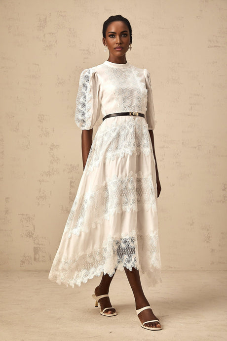 Woman wearing a white midi dress with lace trim panels and belt at waist