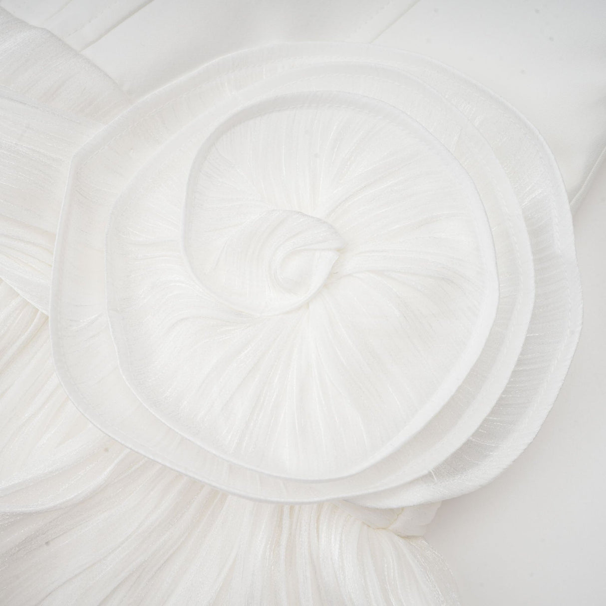 Woman wearing a white mini dress with full pleats and cinched waist detail