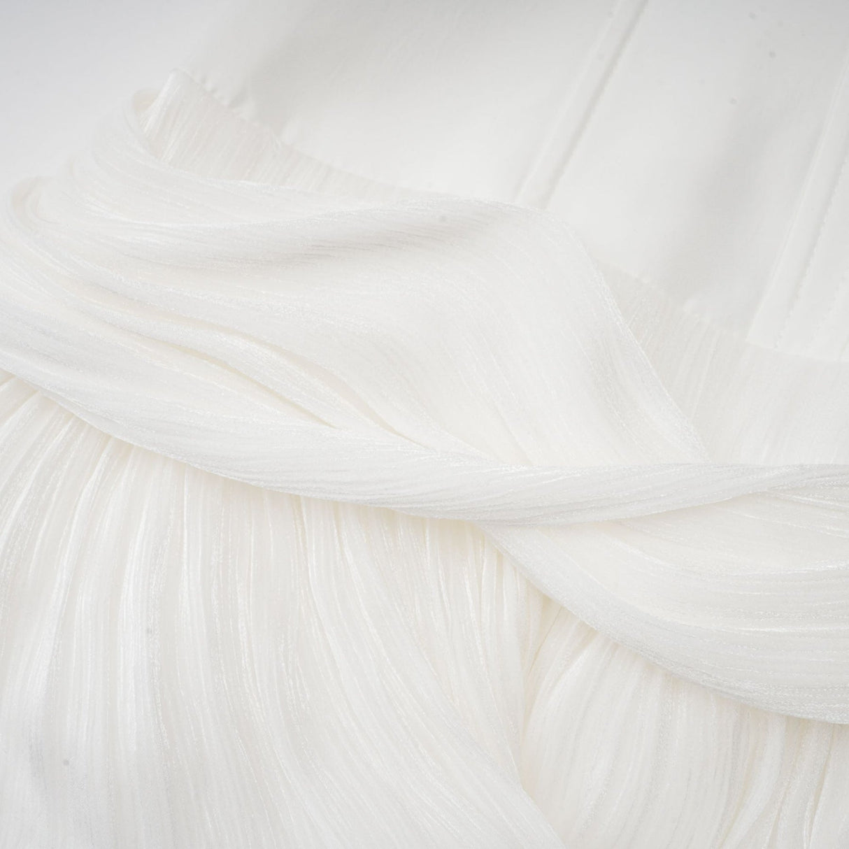 Woman wearing a white mini dress with pleats and cinched waist