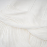 Woman wearing a white mini dress with pleats and cinched waist