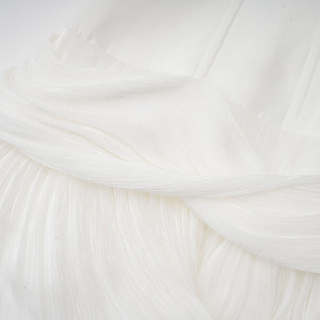 Woman wearing a white mini dress with pleats and cinched waist