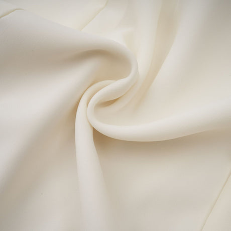 Woman wearing a white pleated jacket and dress set with embellishments The jacket is fitted and the dress has a matching pleated design Both pieces feature decorative embellishments for an elegant look