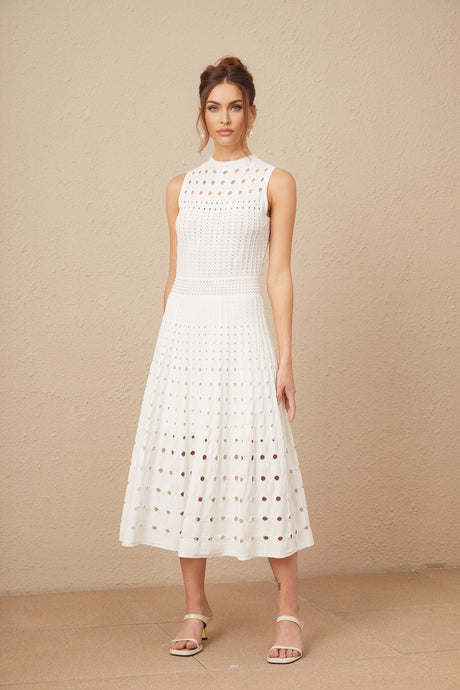 Woman wearing a white sleeveless knitted midi dress with cutout details standing in a neutral pose
